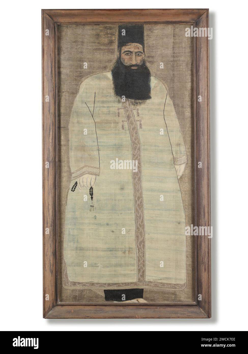 A Qajar silk and metal thread brocade panel with painted details, depicting a Qajar official dressed partly in religious robes and carrying prayer beads, Persia, late 19th Century. Stock Photo