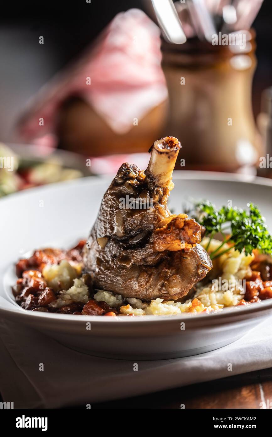 Confit lamb calf on mashed potatoes and baking sauce. Roasted leg of mutton with potatoes on a plate in a restaurant. Stock Photo