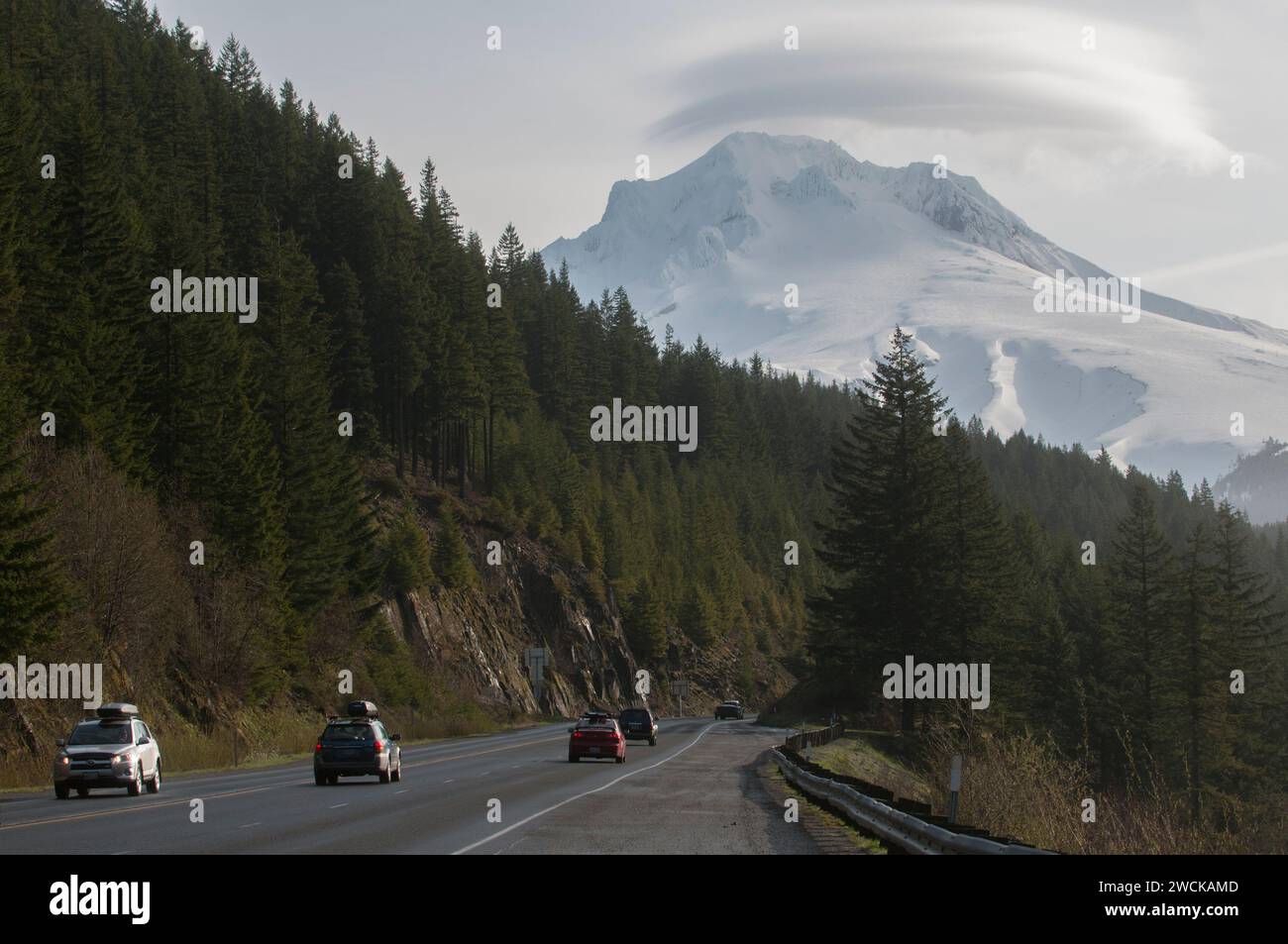 Cars driving on a mist-covered, snow-capped mountain highway in Mount Hood, Oregon Stock Photo