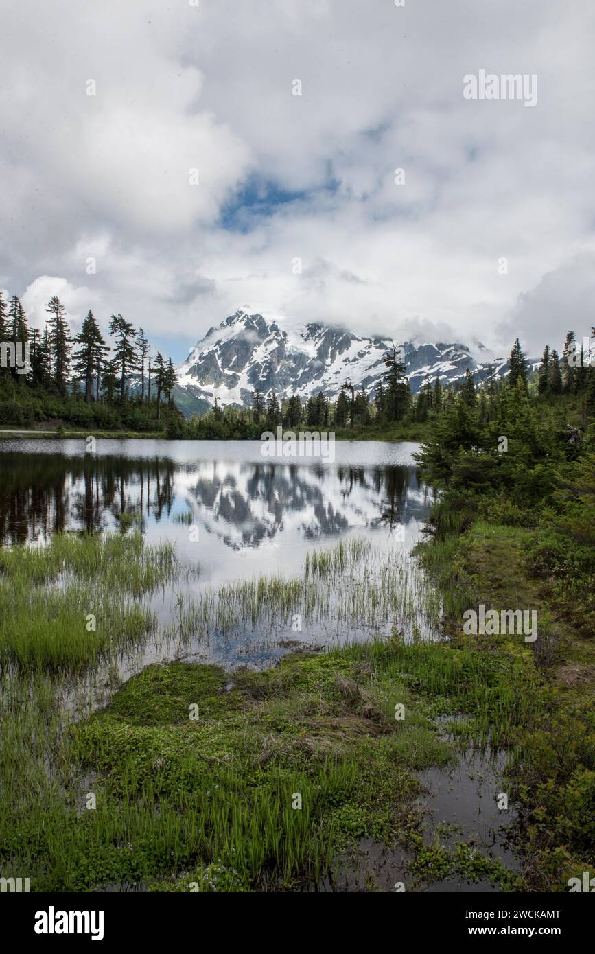 Snow-capped mount Baker and the surrounding valley in serene waters Stock Photo