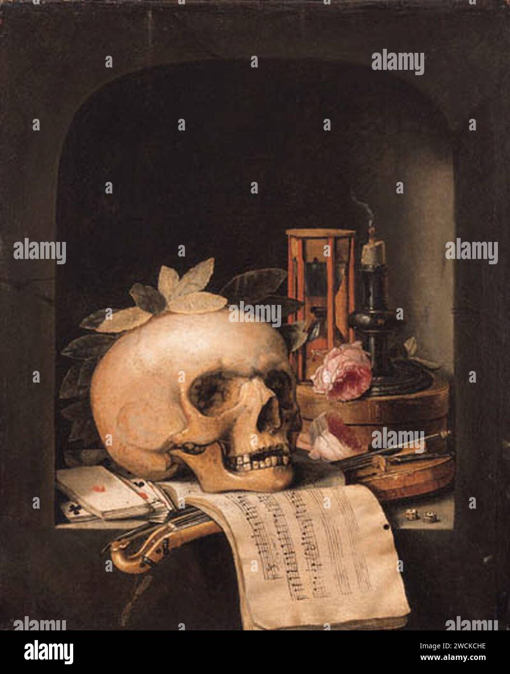 A vanitas still life with a wreathed skull, a Pochette violin and a bow, a deck of cards, a musical score, a pair of dice, a box inscribed poudre de civet, two roses, an hourglass and a snuffed-out candle in a niche112332). Stock Photo