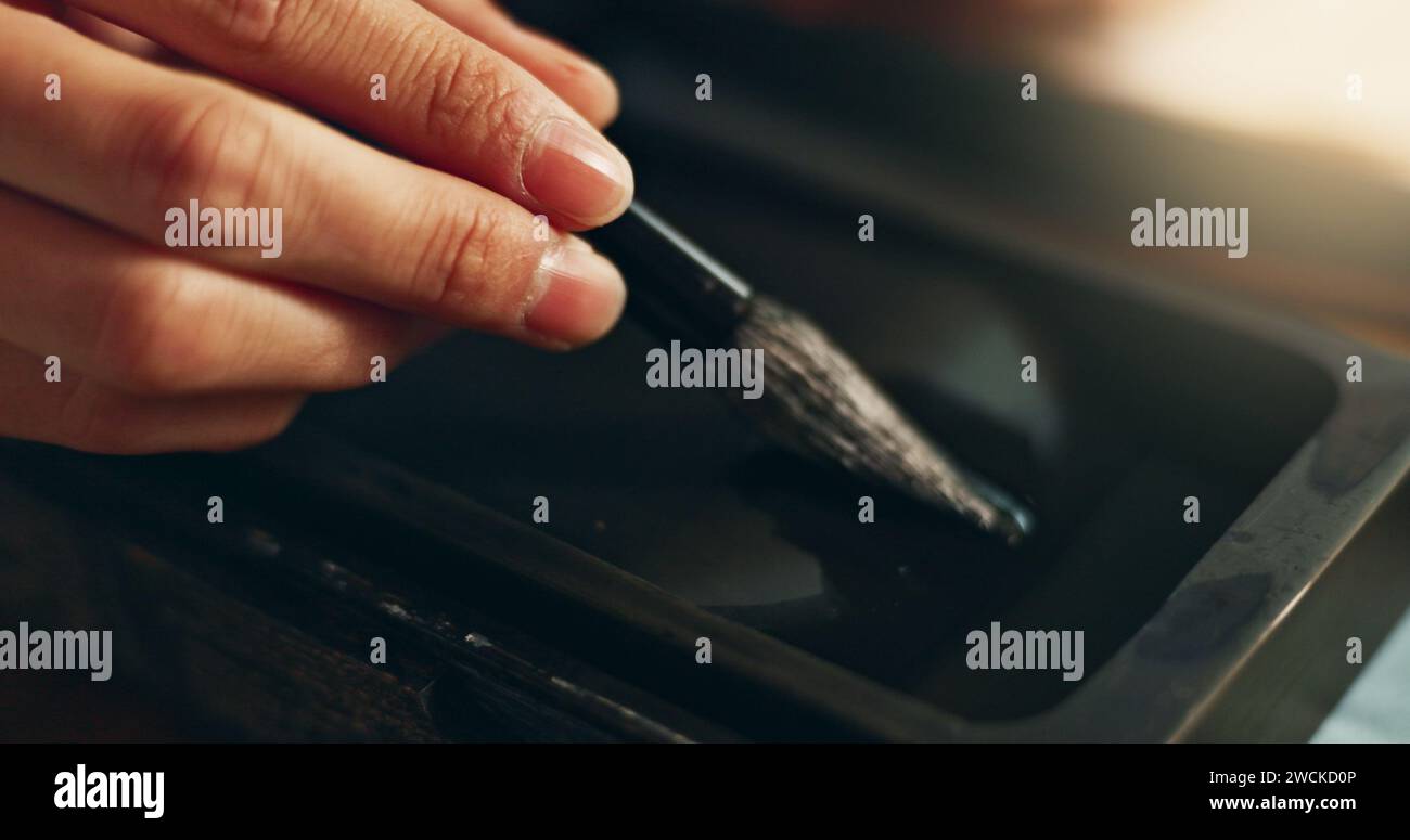 Hand, closeup of brush in ink for writing and calligraphy or ancient stationery for art and inkstone. Japanese creativity, black paint with paintbrush Stock Photo