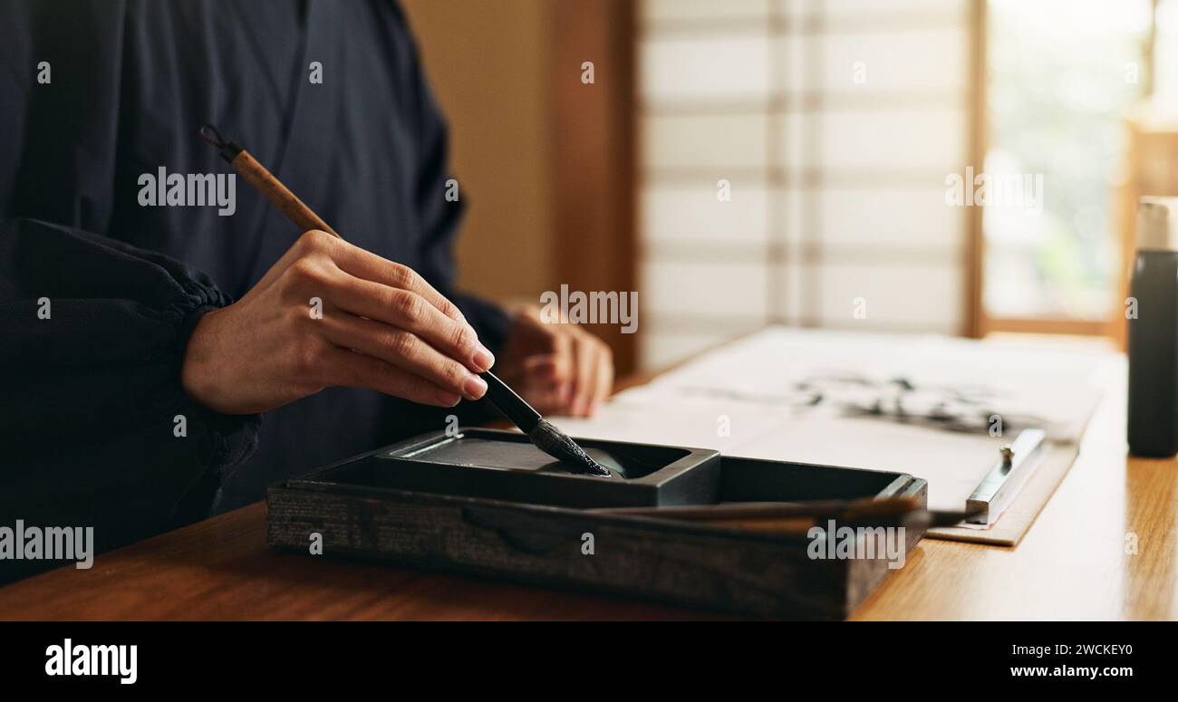 Hands, reed pen or brush in ink for writing, calligraphy or ancient