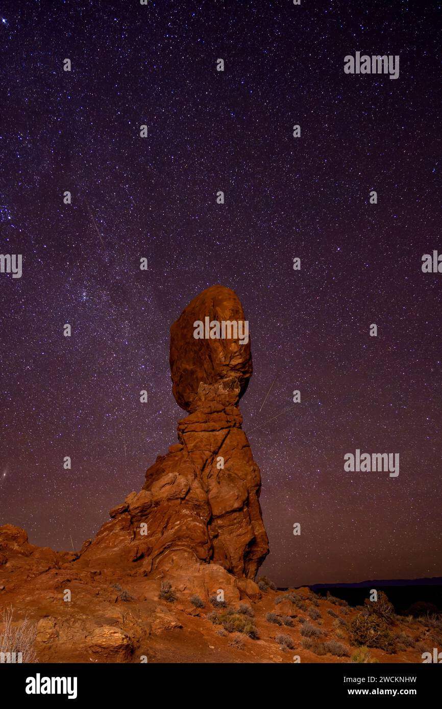 Geminid Meteor Shower over Balanced Rock in Arches National Park in Utah.  Composite image shows 5 faint meteorites over a 2-hour period. Stock Photo