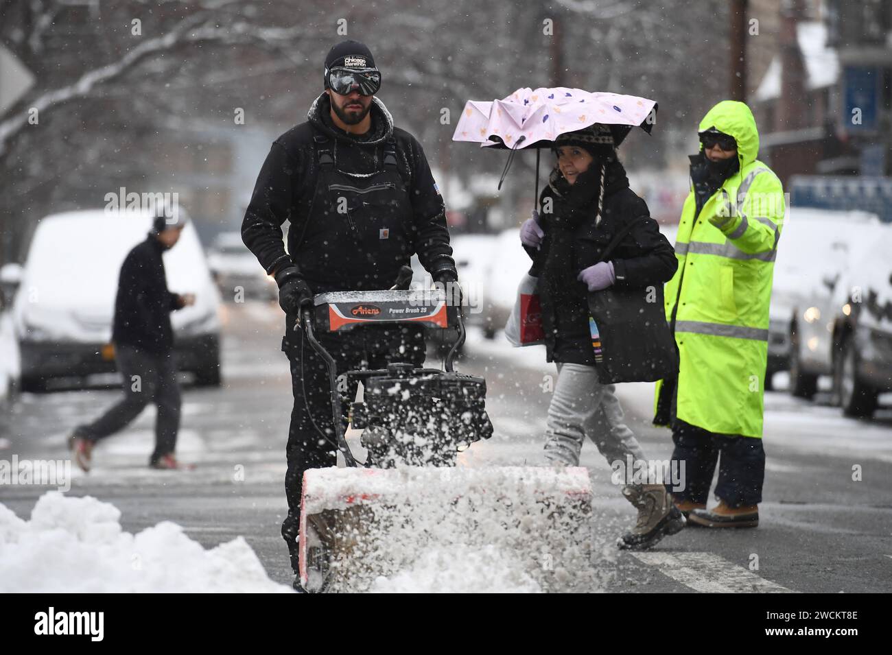 New York, USA. 16th Jan, 2024. A man uses a snow blower to clear a