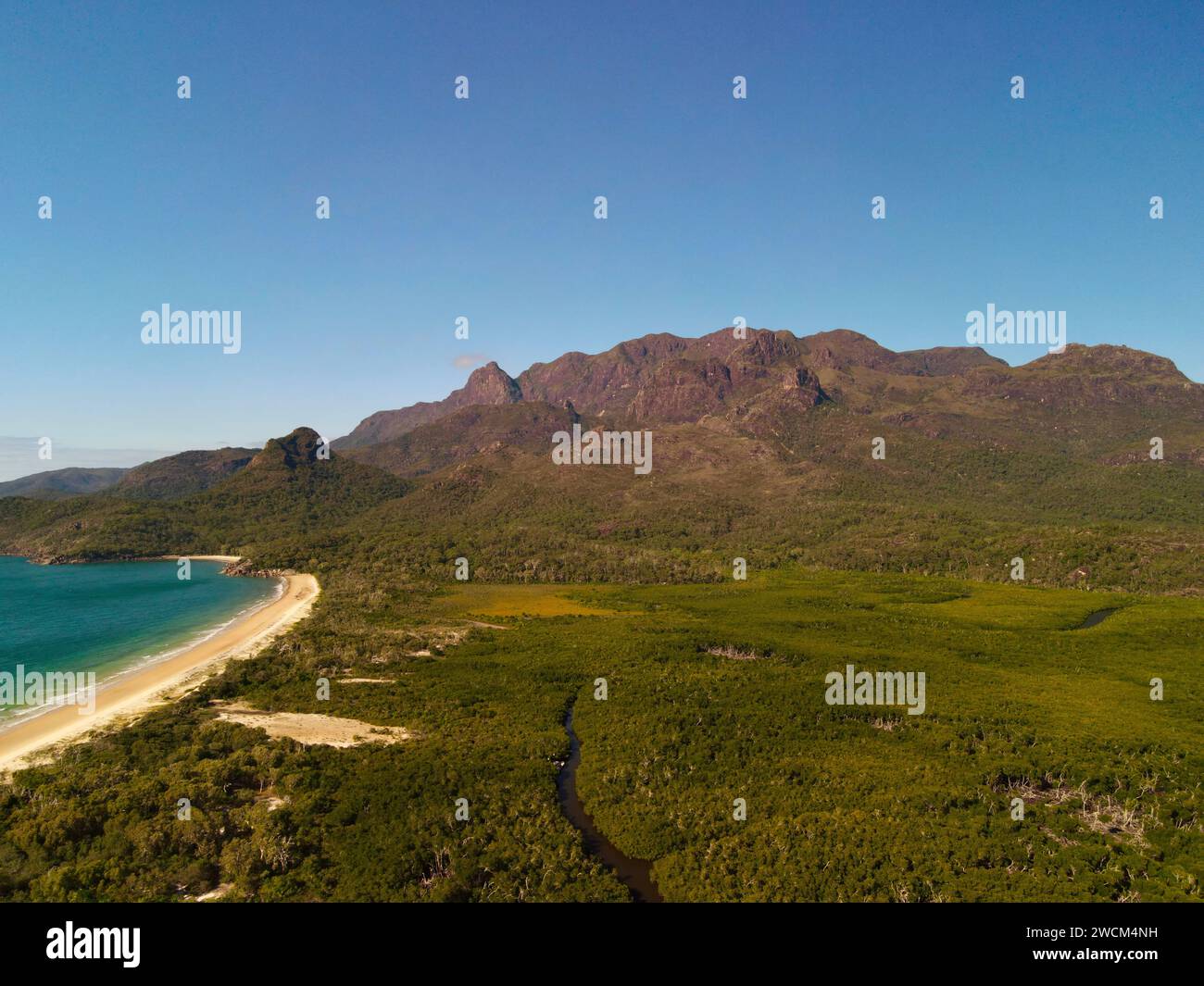 Aerial perspective of beaches, mountains, and lush greenery from an