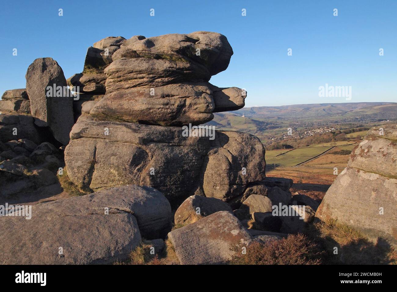 Rock formation near Higger Tor, Peak District, Derbyshire, with Edale and Bamford concrete factory in the distance Stock Photo