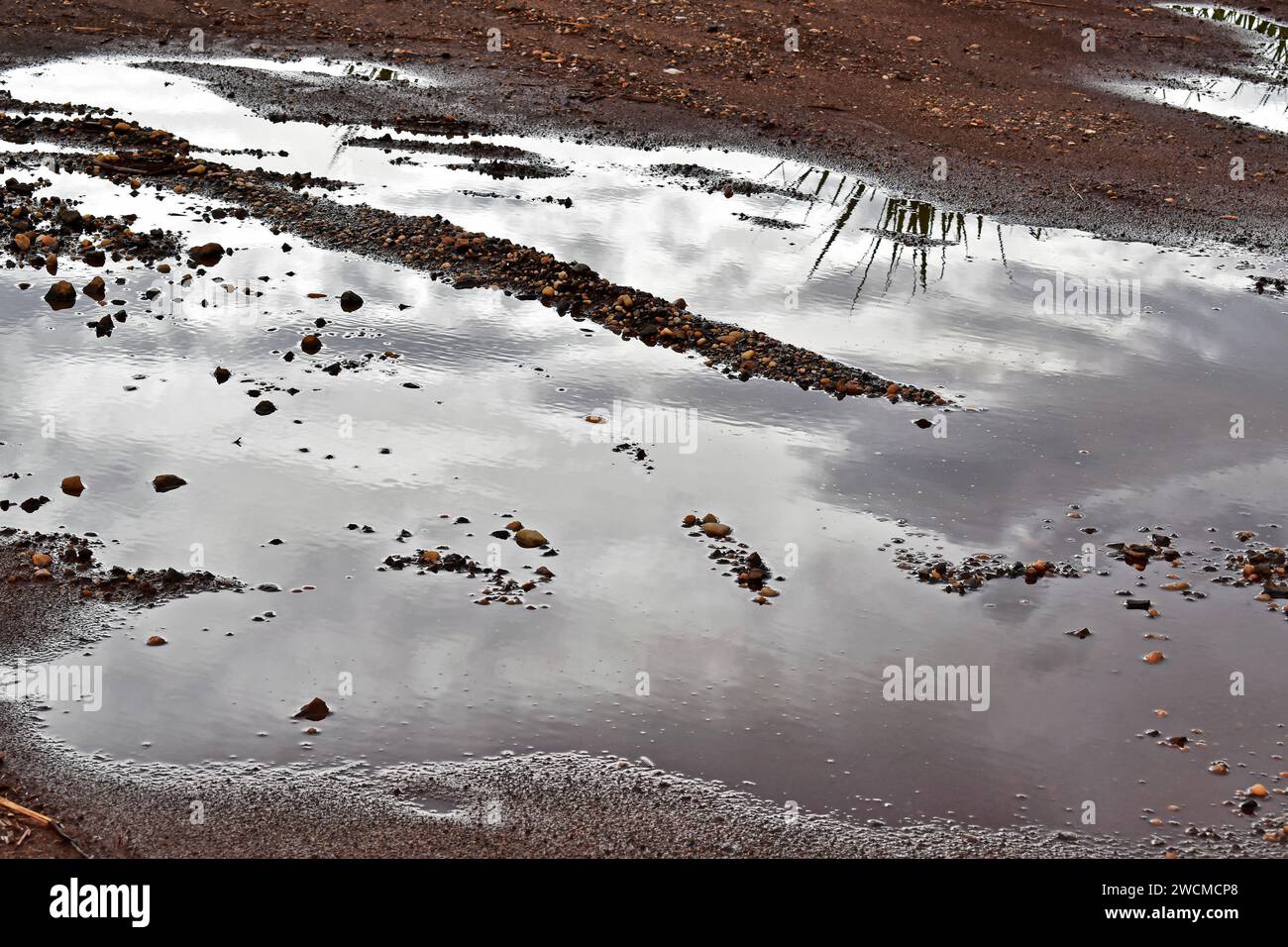 Puddle of water reflecting sky Stock Photo