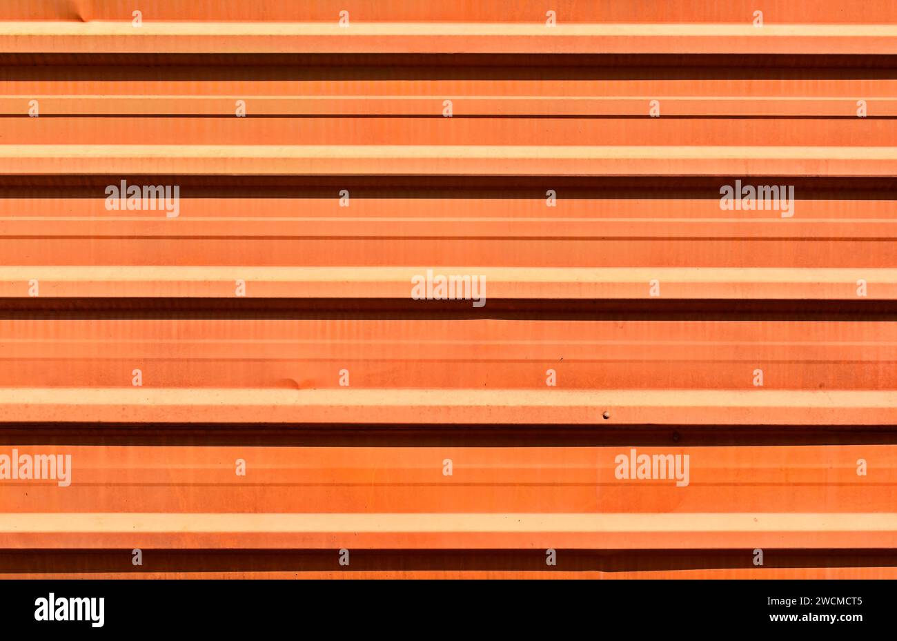 Orange corrugated metal plate surrounding wasteland Stock Photo