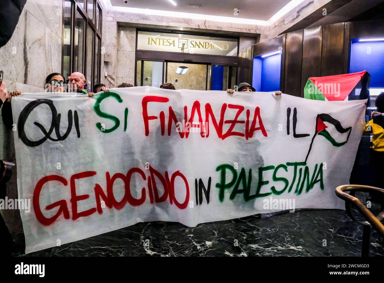 Pro-Palestinian blitz at the Intesa Sanpaolo bank Pro-Palestinian blitz at the Intesa Sanpaolo headquarters in via Toledo. This afternoon, a few dozen activists burst into the intesa san paolo bank building, chanting chants and slogans for the people of Gaza. Here the genocide in Palestine is being financed reads a large banner unfurled in front of the bank, papered by the protesters with leaflets depicting the macabre images of children who died under bombing in the Middle East. DSCF1340 Copyright: xAntonioxBalascox Stock Photo