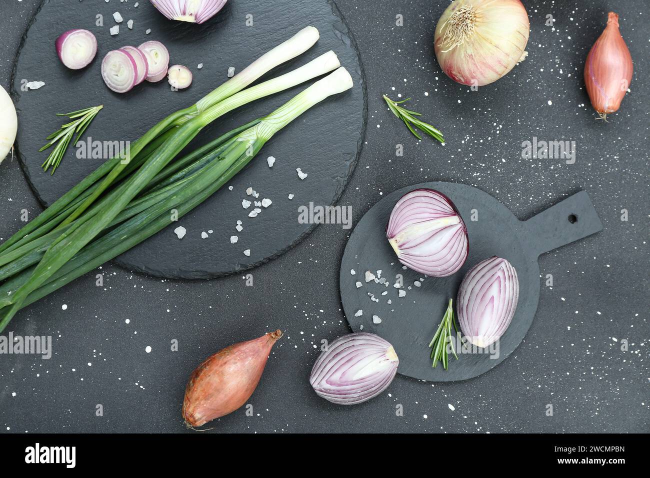 Boards with different kinds of onion on grunge black background Stock ...