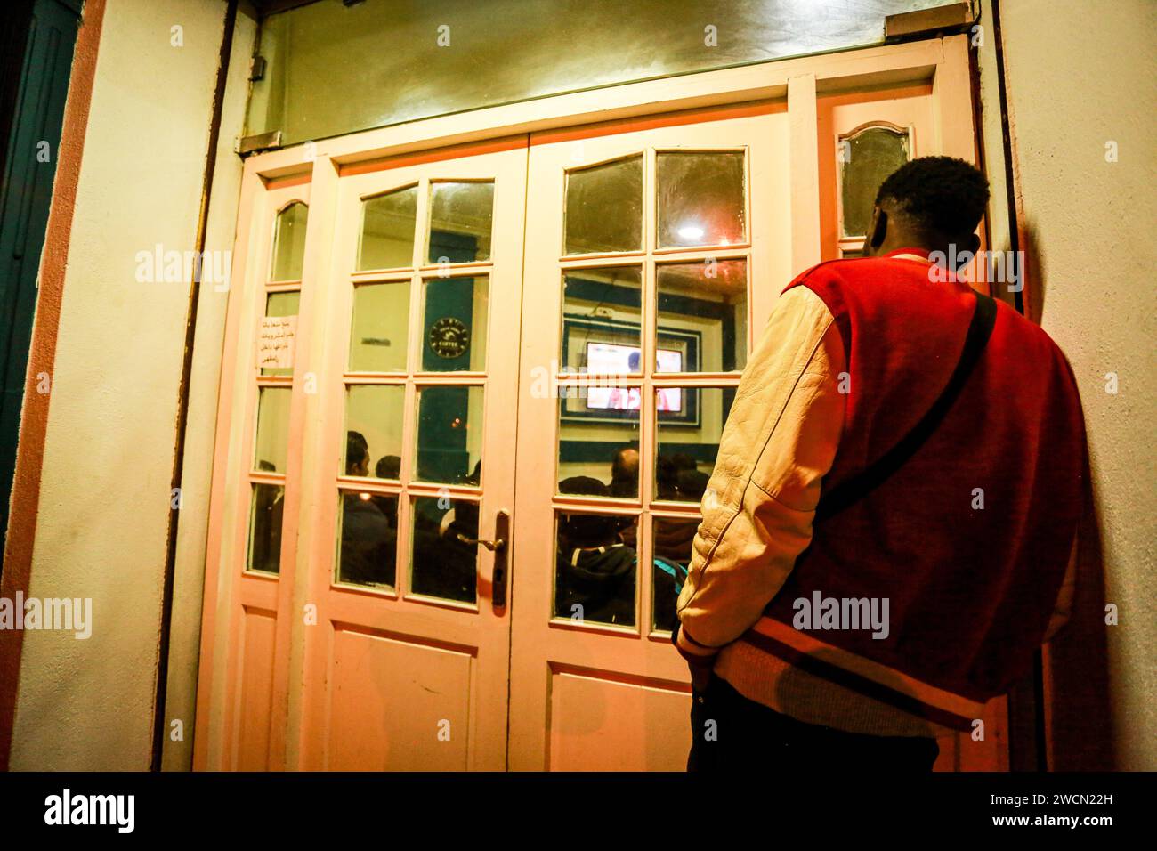 January 16, 2024: Tunis, Tunisia. 16 January 2024. Tunisian football fans watch the Tunisia vs Namibia match on a tv screen in Tunis. The match, which is being played at the Amadou Gon Coulibaly Stadium at Korhogo in Ivory Coast, is part of the Africa Cup of Nations (Credit Image: © Hasan Mrad/IMAGESLIVE via ZUMA Press Wire) EDITORIAL USAGE ONLY! Not for Commercial USAGE! Stock Photo