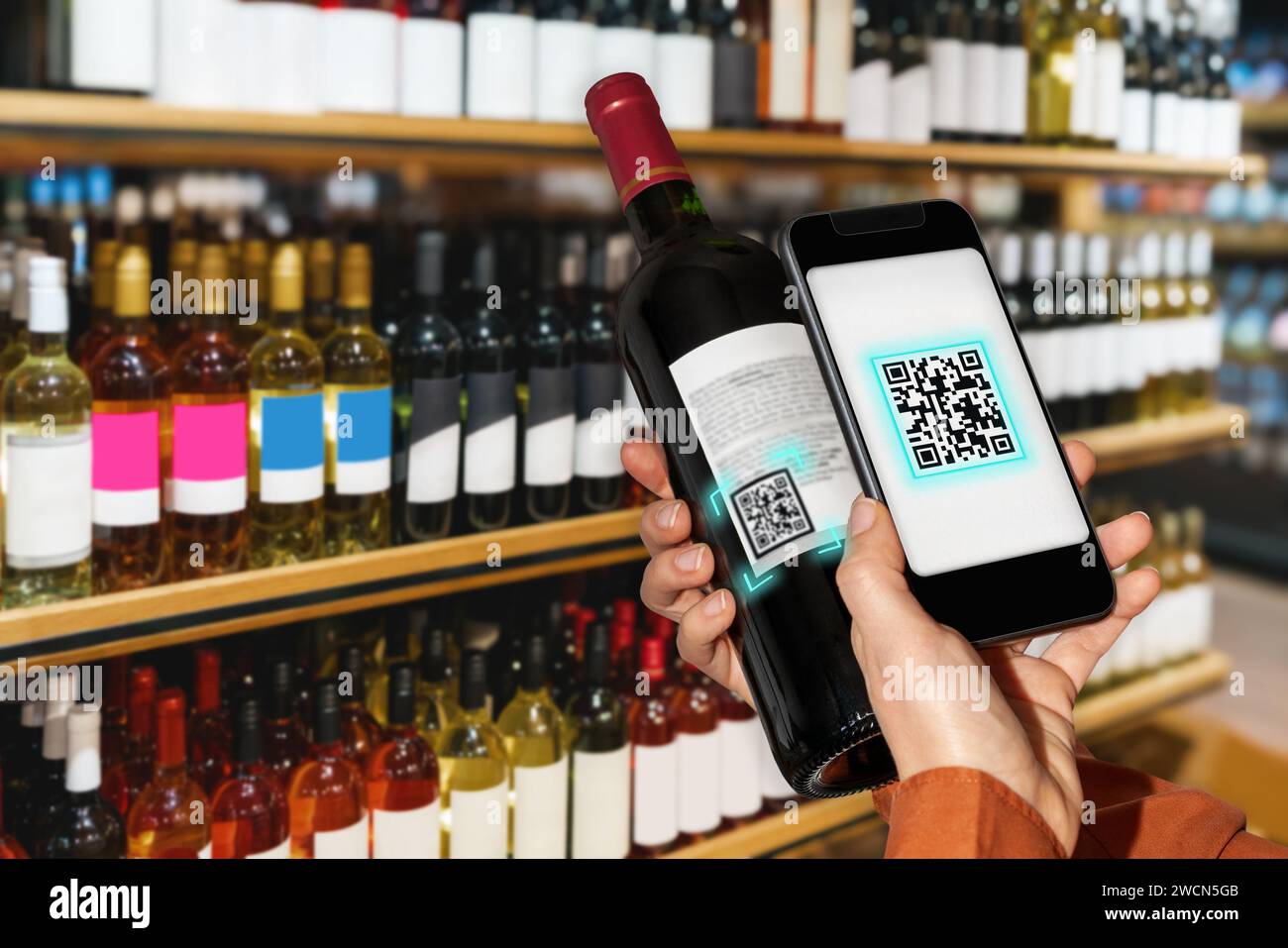 Scanning elabel of wine bottle by smart phone in liquor store Stock