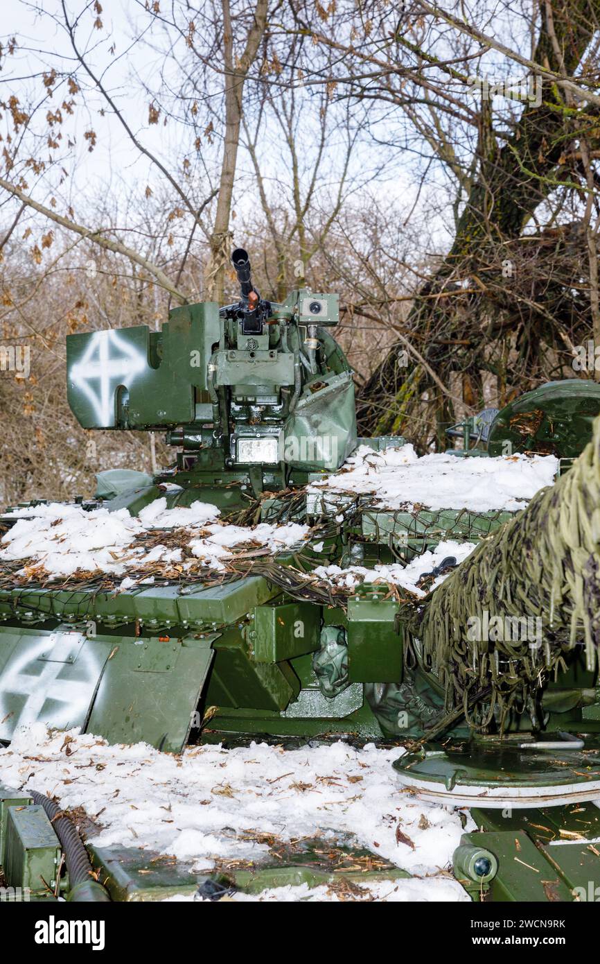Military equipment is seen on the tank's turret. Tank battalion of the 41st Mechanized Brigade of the Armed Forces of Ukraine in Kharkiv region, Ukraine. The war of the Russian Federation against Ukraine has been going on for 2 years now. Ukrainian troops are courageously defending their country. Stock Photo