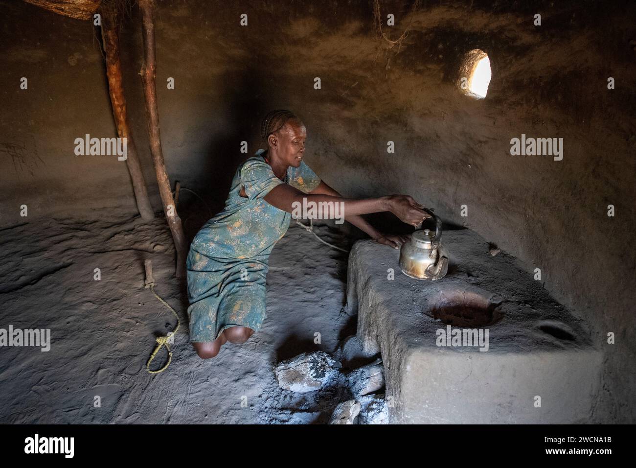 Uganda, Adjumani. A South Sudanese refugee cooks in her kitchen. Editorial use only. Stock Photo