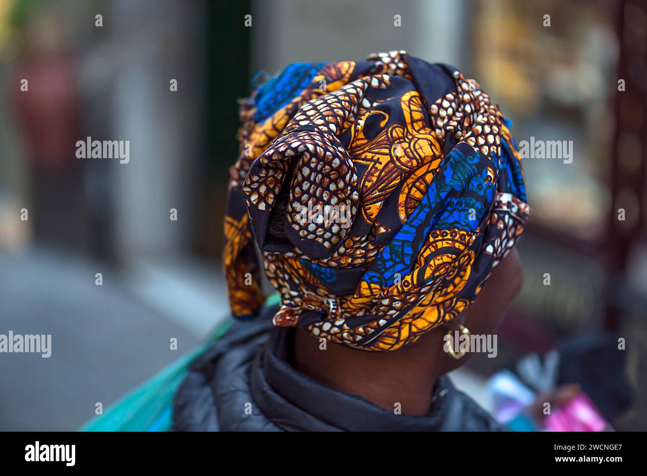 Colourful turban of a black immigrant woman in the old town of Genoa, Italy Stock Photo