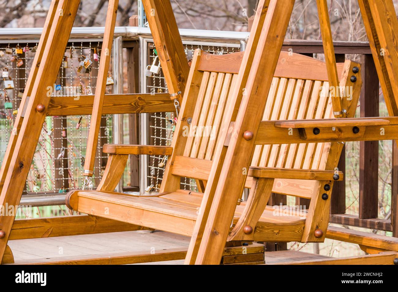 Closeup of beautiful wooden swing bench on wooden flooring in front of ...