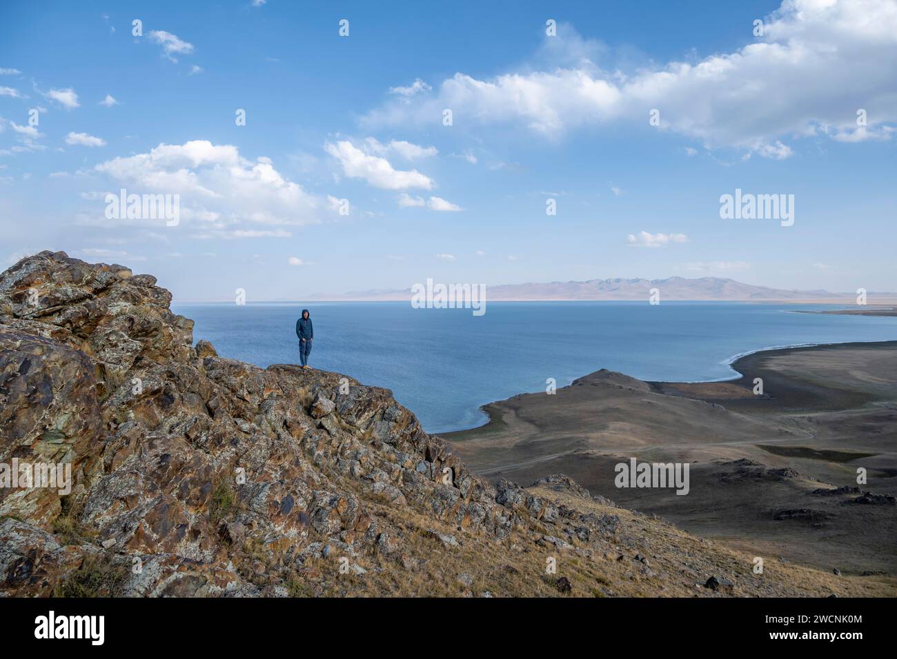 Tourist standing on a hill, view of mountain lake Song Kul, Naryn region, Kyrgyzstan Stock Photo