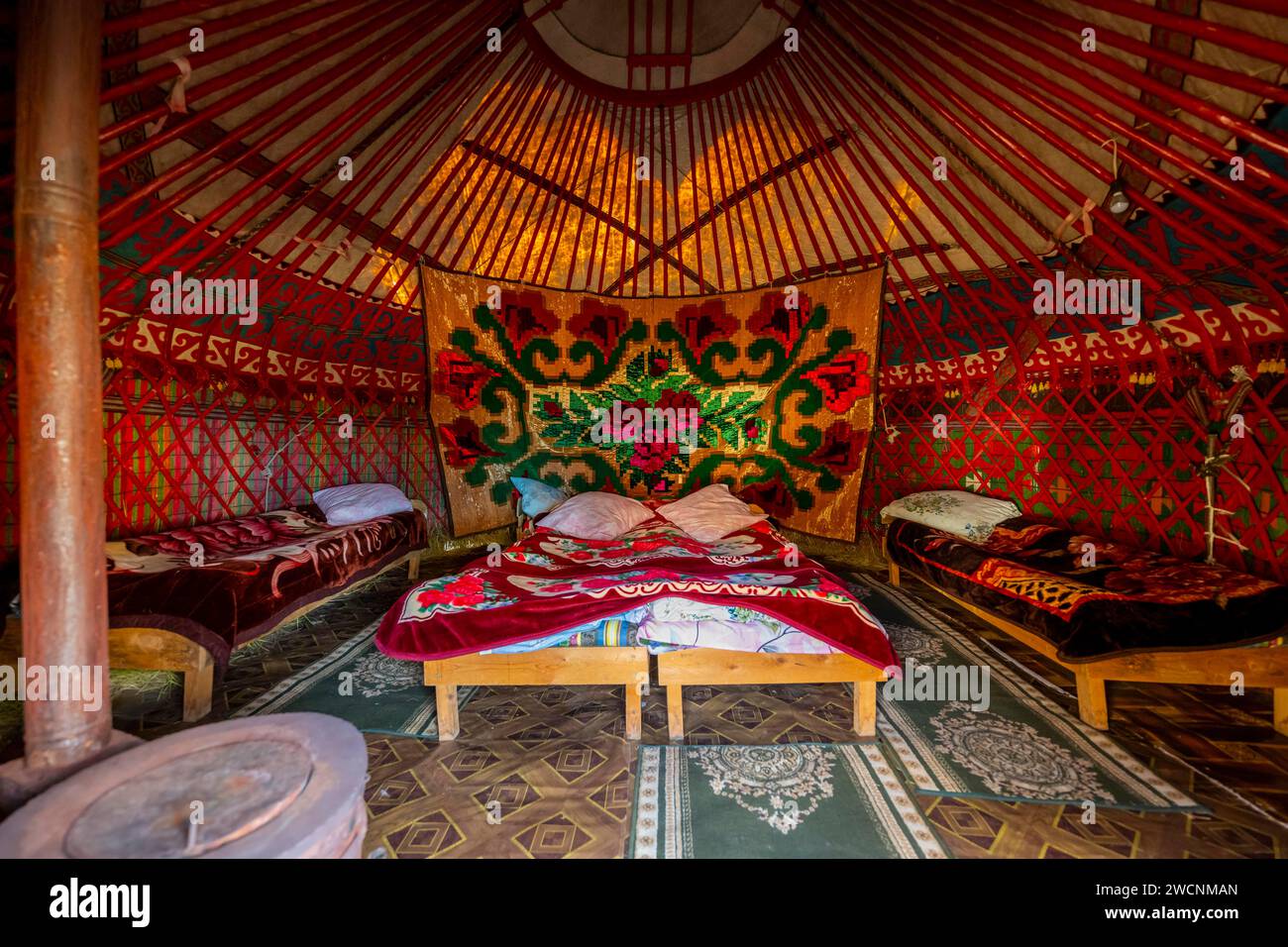 Traditional Kyrgyz yurt for overnight accommodation for tourists, with four beds and carpets, Naryn region, Kyrgyzstan Stock Photo