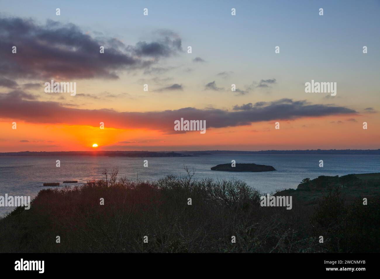 View at sunset from the Pointe de l'Armorique over the bay Rade de Brest with the small island Ile Ronde, behind the peninsula Presqu'ile de Crozon Stock Photo