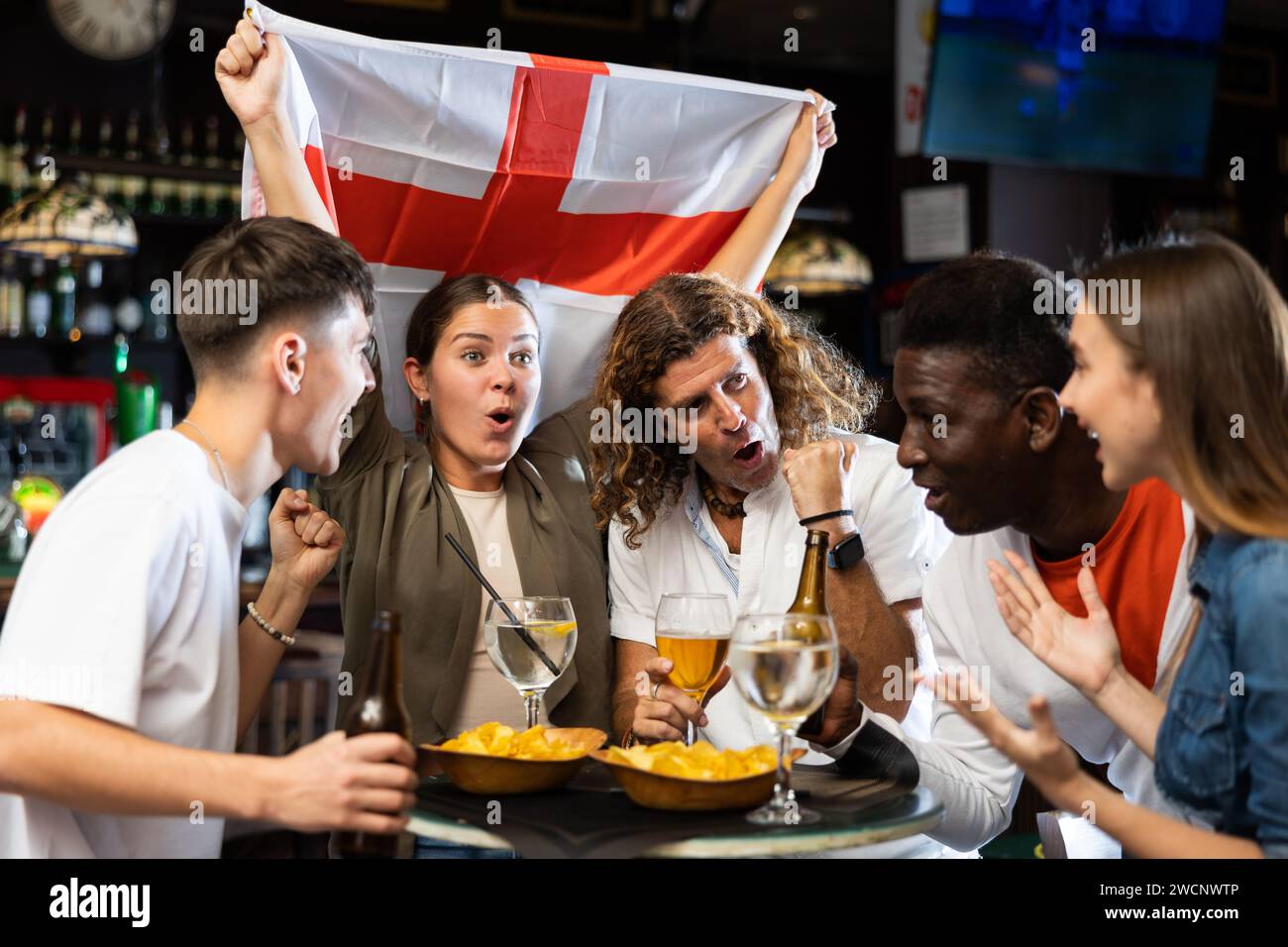 Group of football fans rooting for England team in sports bar Stock Photo