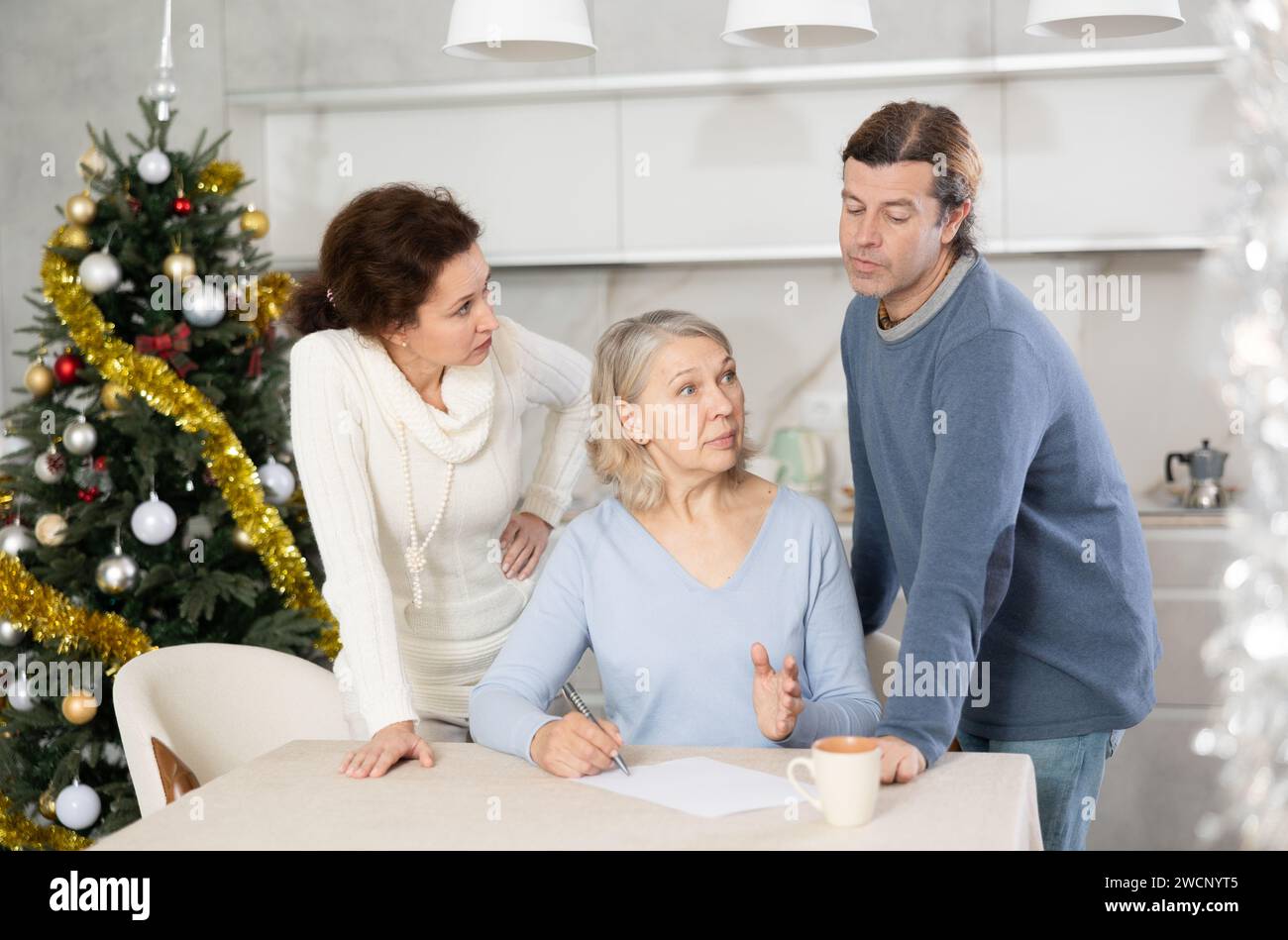 Man and woman help elderly mother make will and fill out document