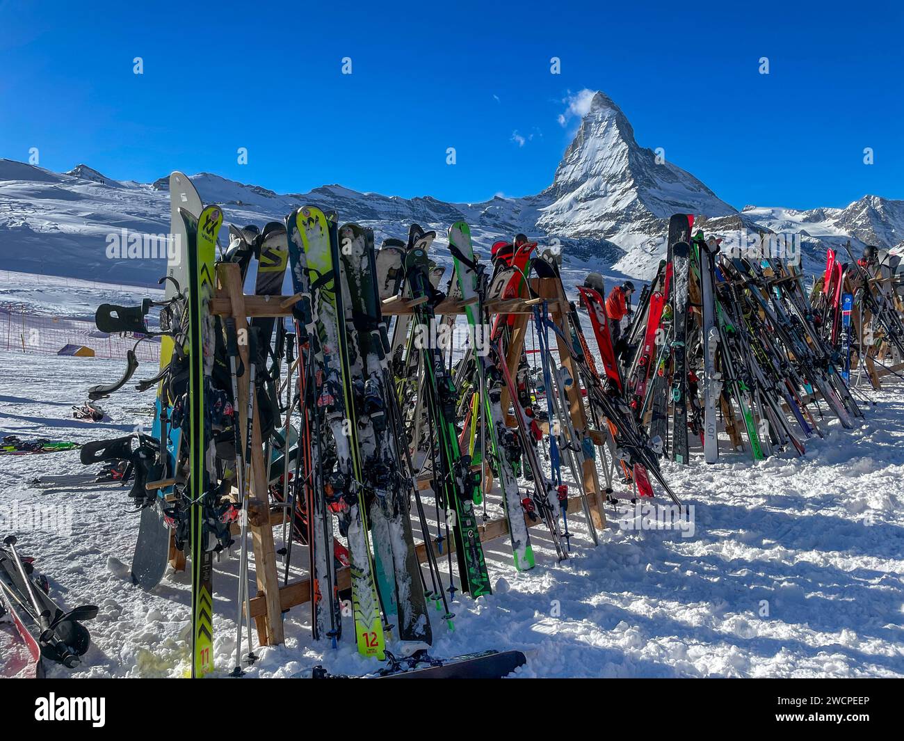 Skis rest on a rack near a mountain lodge at Zermatt ski resort with ...