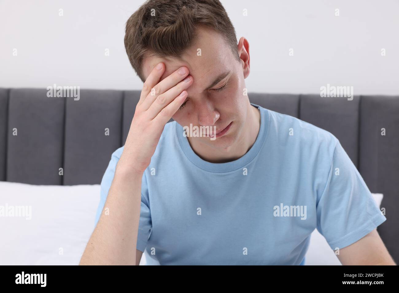 Sad man suffering from headache at home Stock Photo - Alamy