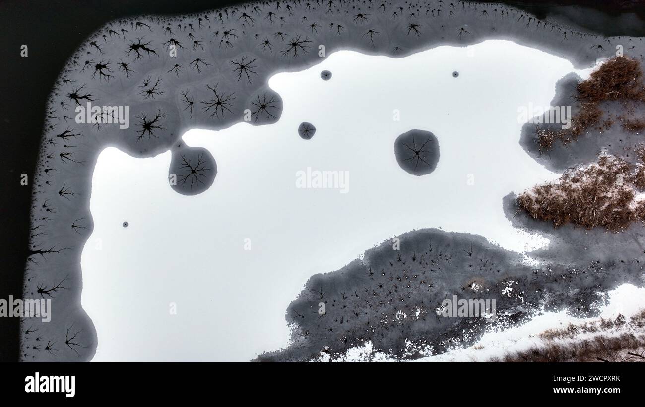 ZOUCHENG, CHINA - JANUARY 16, 2024 - The 'Eye of snow and ice' is seen on the lake after snow in Kuangheng Lake Wetland Park in Zoucheng city, Shandon Stock Photo