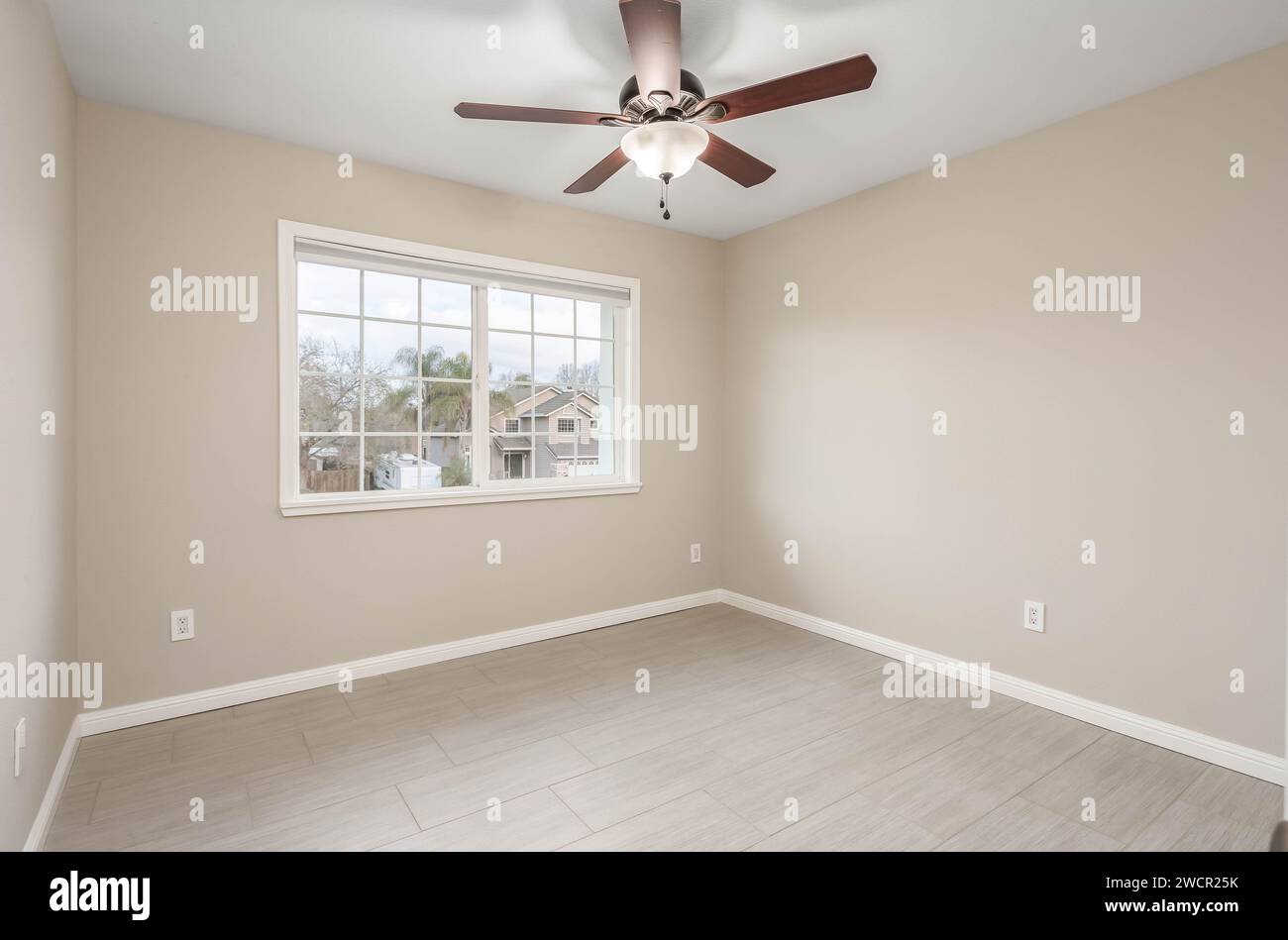 Empty Real Estate bedroom with bright walls, ceiling fan and windows. Great for virtual staging and real estate content Stock Photo