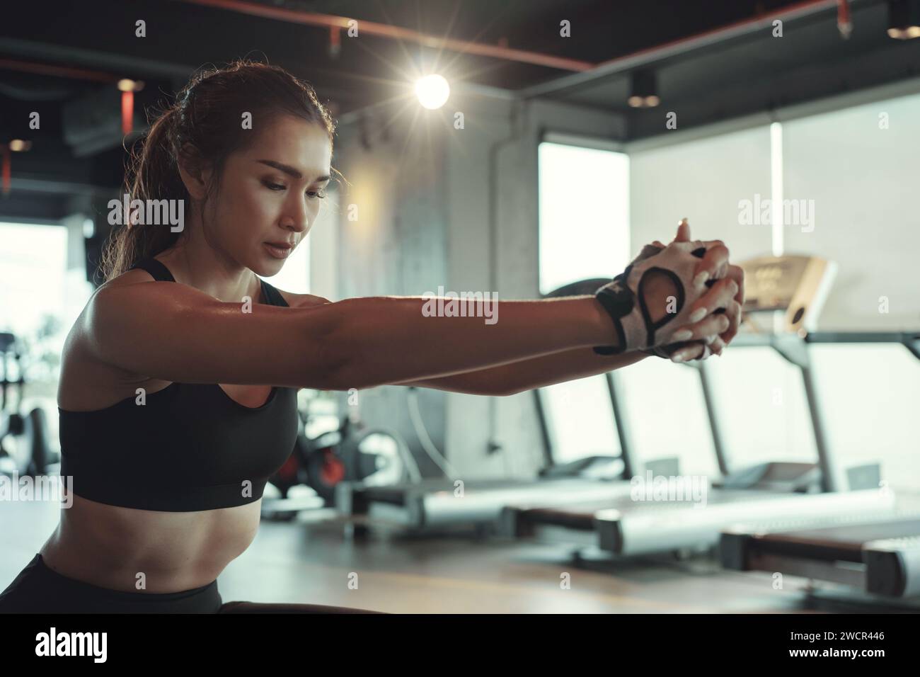 Sporty woman doing workout and using fitball by sitting and balancing on it. Stock Photo