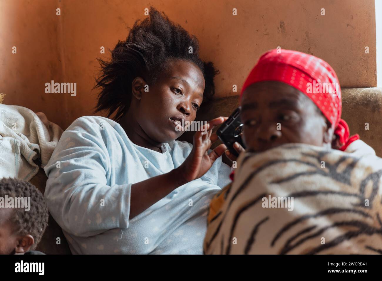 african family in the house , adult woman using the phone, old lady