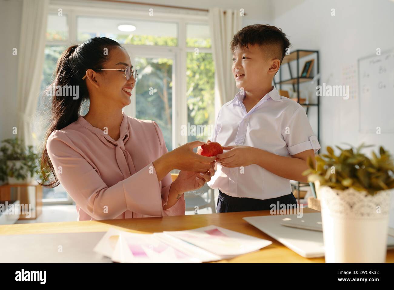Child giving present to teacher hi-res stock photography and images - Alamy