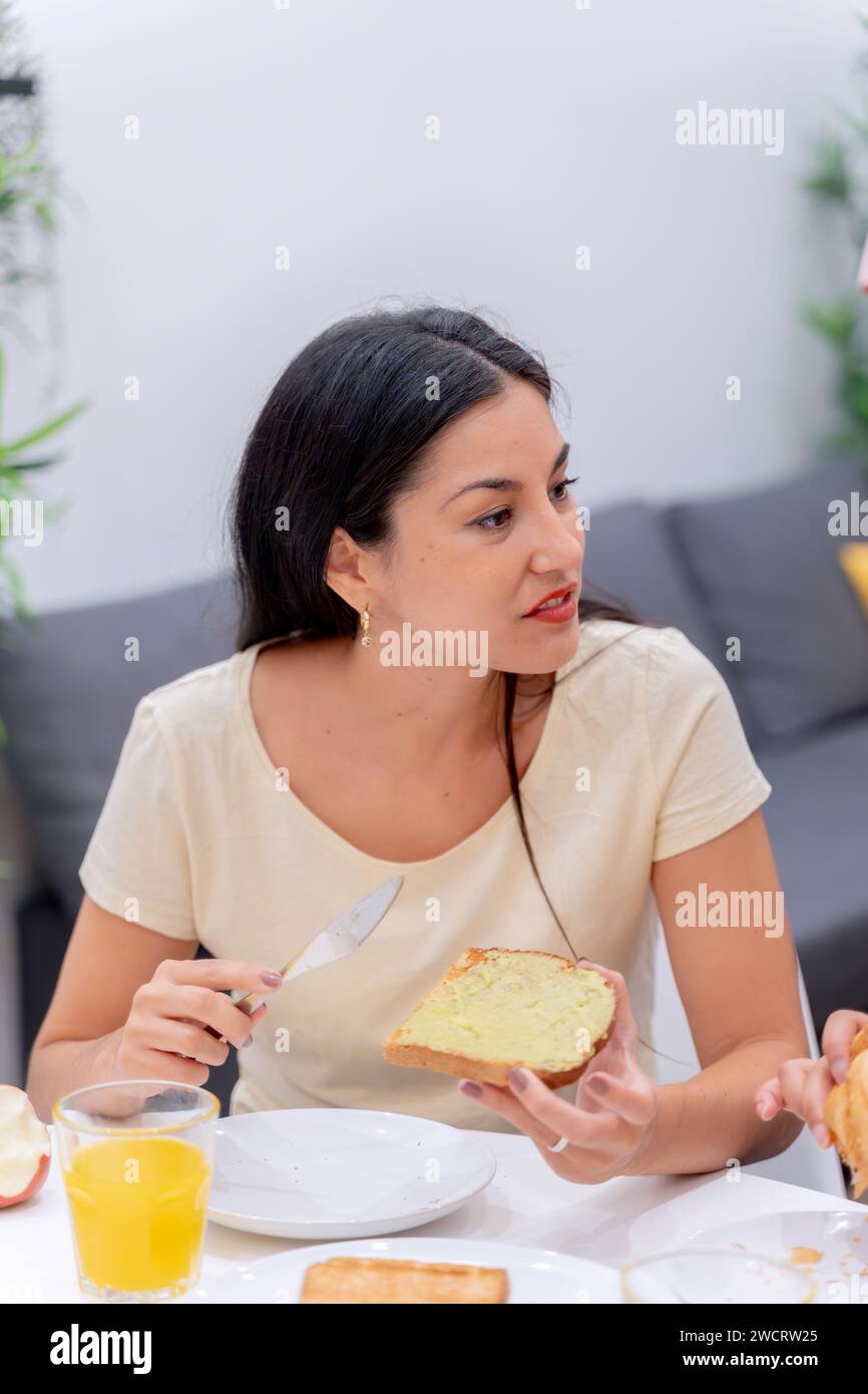 Woman applying butter to bread for her morning routine Stock Photo - Alamy
