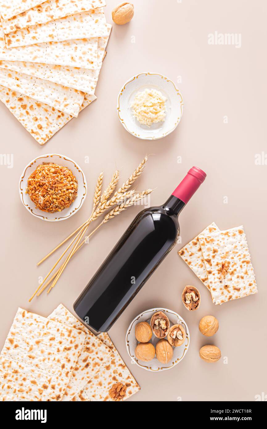 Bottle of red kosher wine, matzoth bread, walnuts, fruit mix on beige