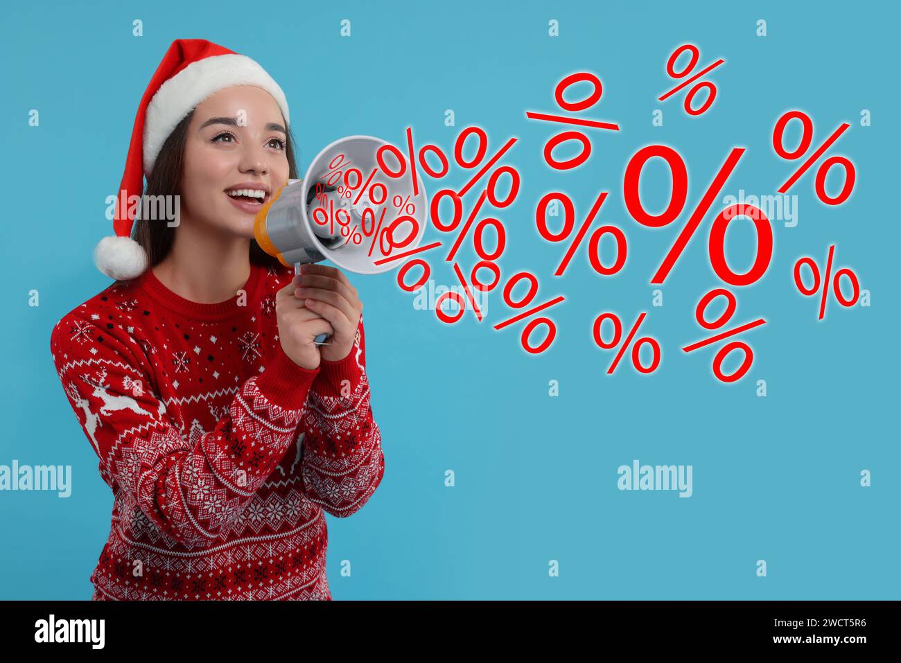 Discount offer. Woman in Christmas sweater and Santa hat shouting in megaphone on light blue background. Percent signs flying out of device Stock Photo