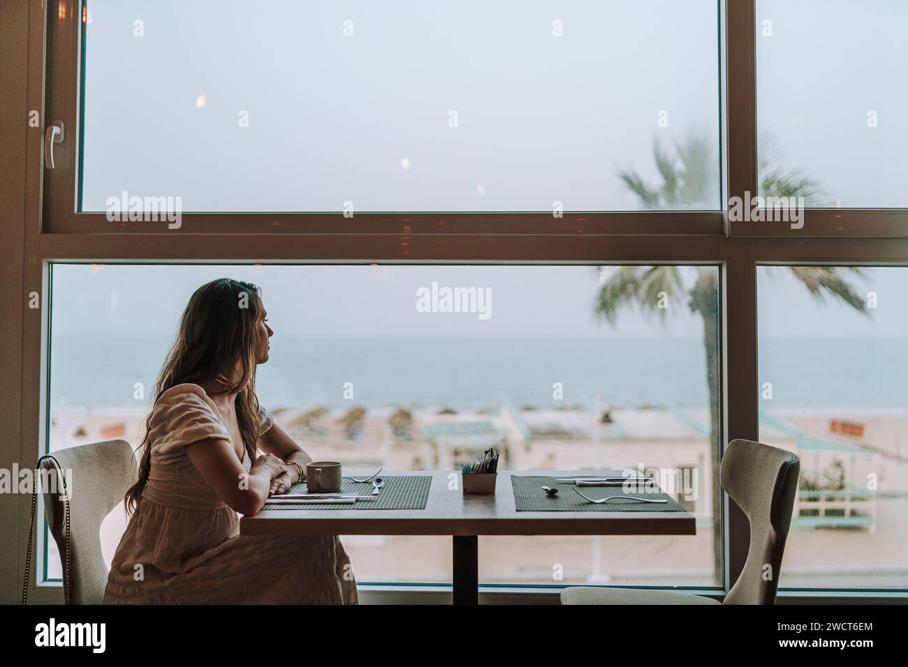 Woman seated at a table by a window hi-res stock photography and images ...