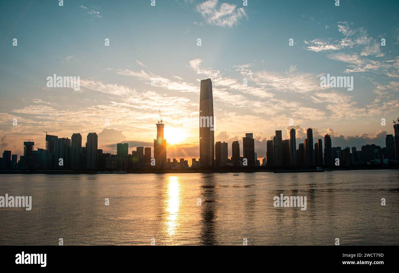 The sunrise on the Wuchang Beach of the Yangtze River, with skyscrapers built on the banks of the river. Stock Photo