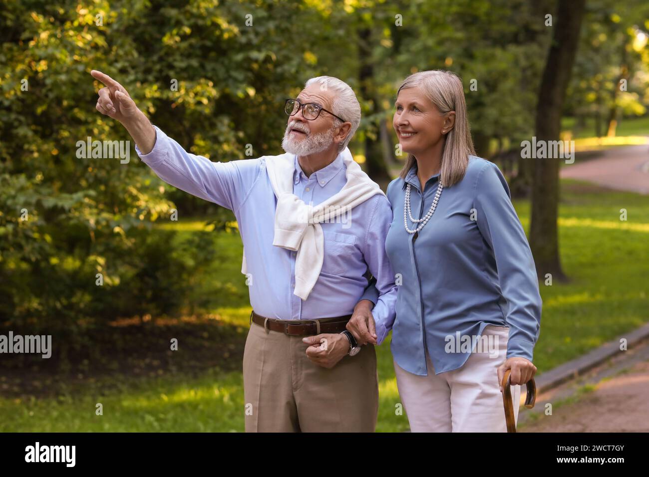 Senior man with walking cane and mature woman in park Stock Photo - Alamy
