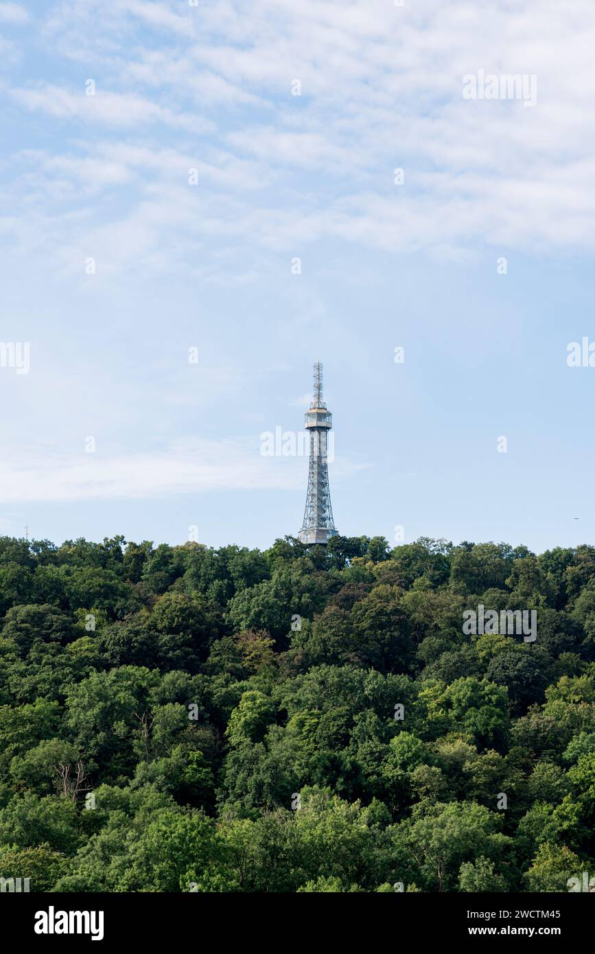 Captured in Prague, Czech Republic, this photo features a scenic view of Petrin Tower surrounded by lush greenery Stock Photo