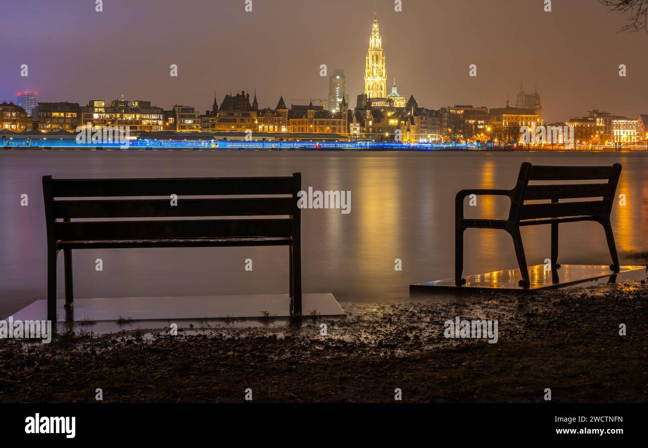Skyline of Antwerp, Belgium, in the evening. Park benches with a view on the river Scheldt and The Cathedral of Our Lady Stock Photo