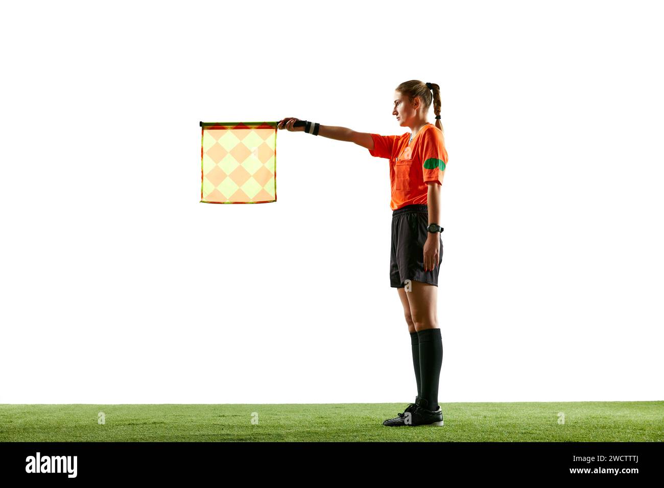Assistant referee, young woman in uniform standing on field and raising