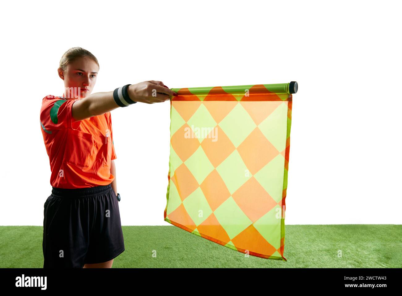 Focus on flag. Young woman, assistant referee raising flag up meaning