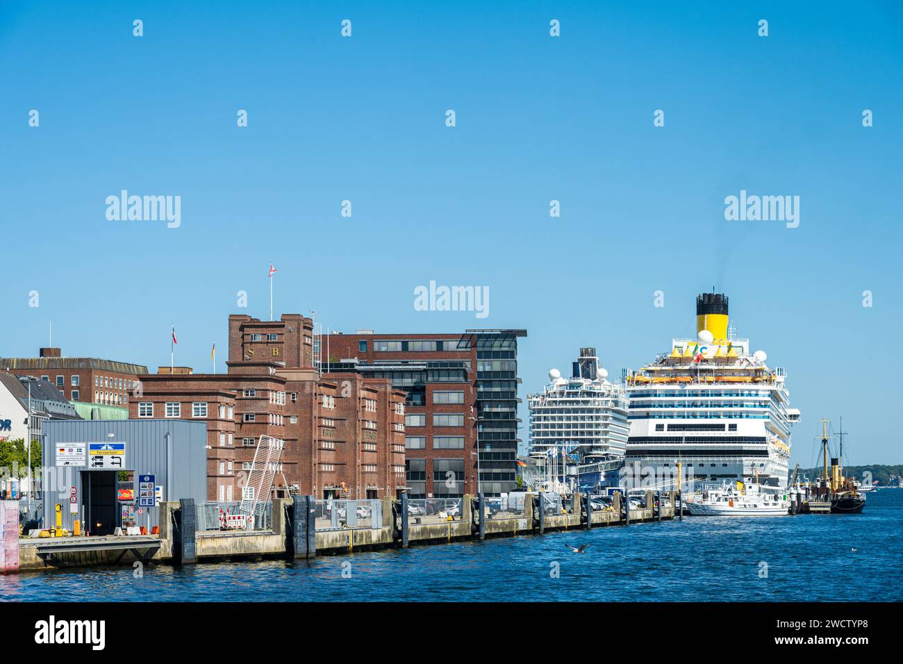 Aufnahme vom Sartorikai mit dem Sartorispeicher und dem Sellspeicher. Im Hintergrund zwei Kreuzfahrtschiffe am Ostseekai in Kiel Stock Photo