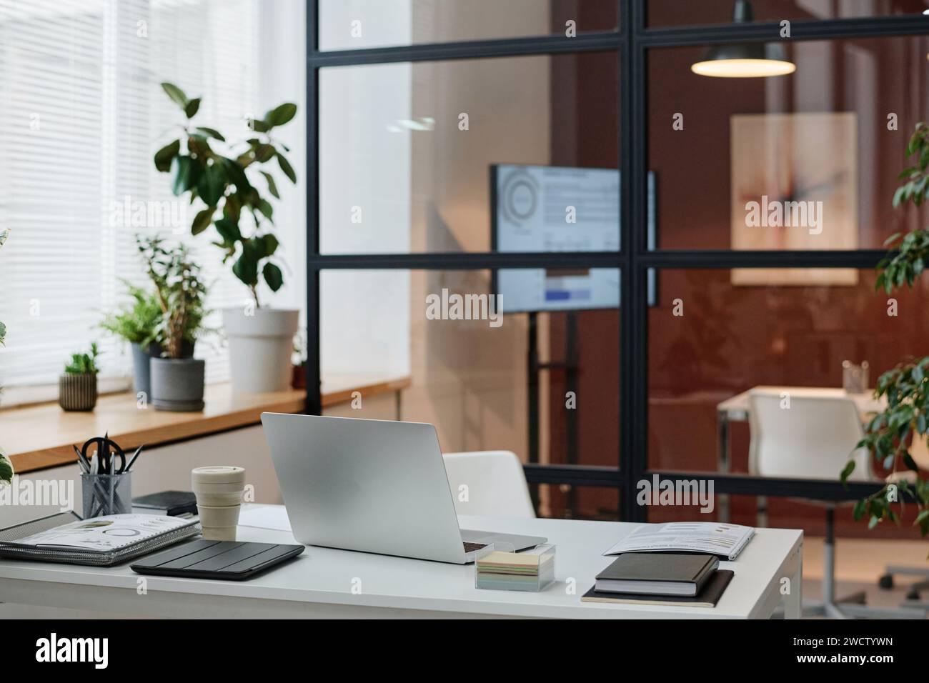 Modern urban office interior with neat white table placed against glass