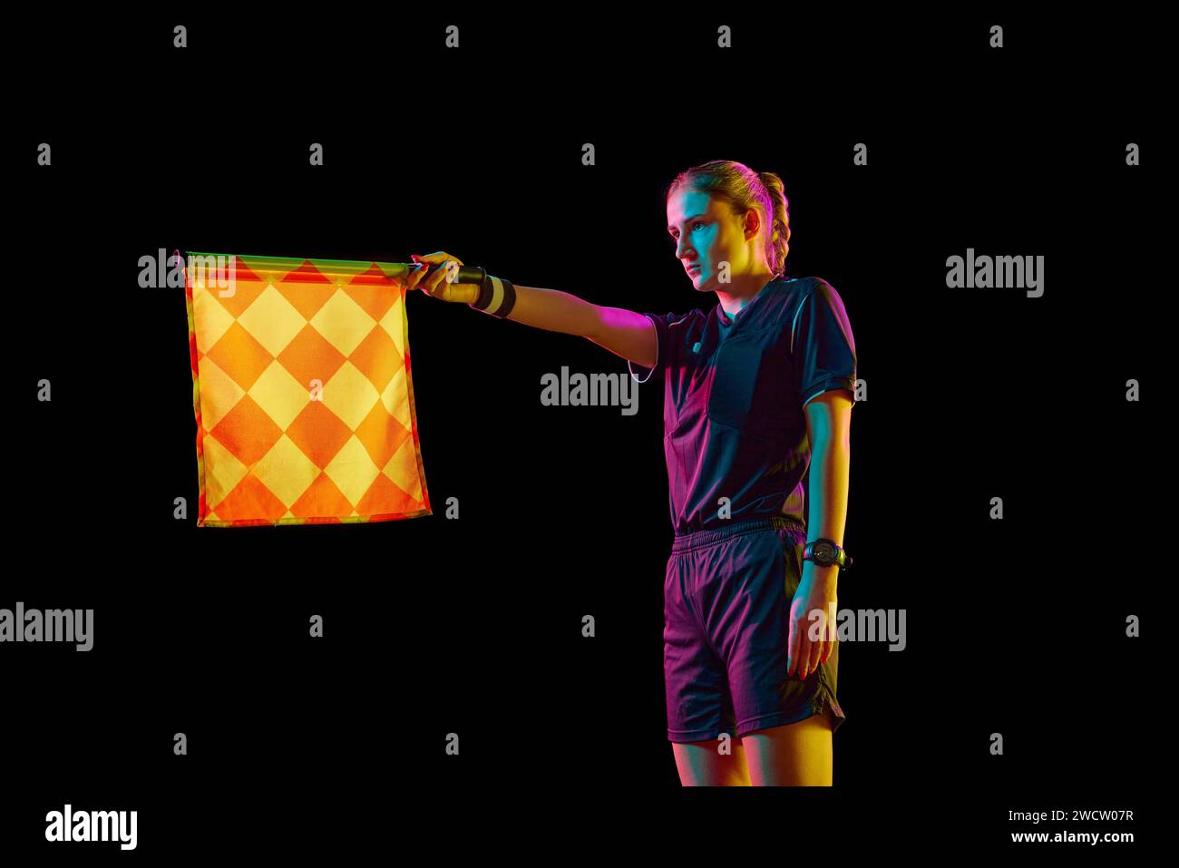 Young woman, assistant referee raising flag up meaning offside position