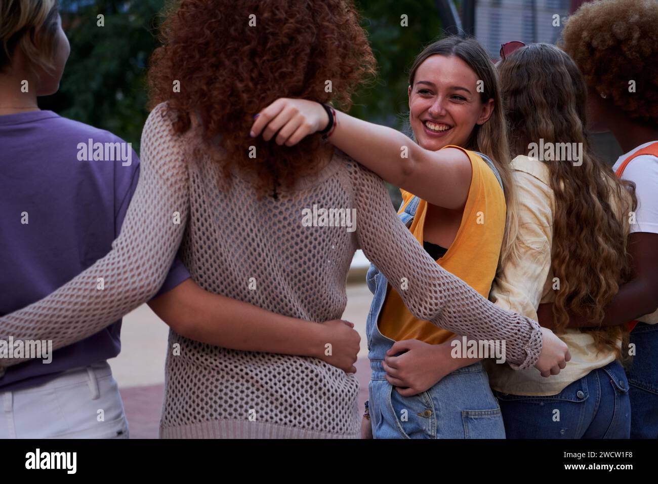 Group of happy young multiracial people embracing together outdoors ...