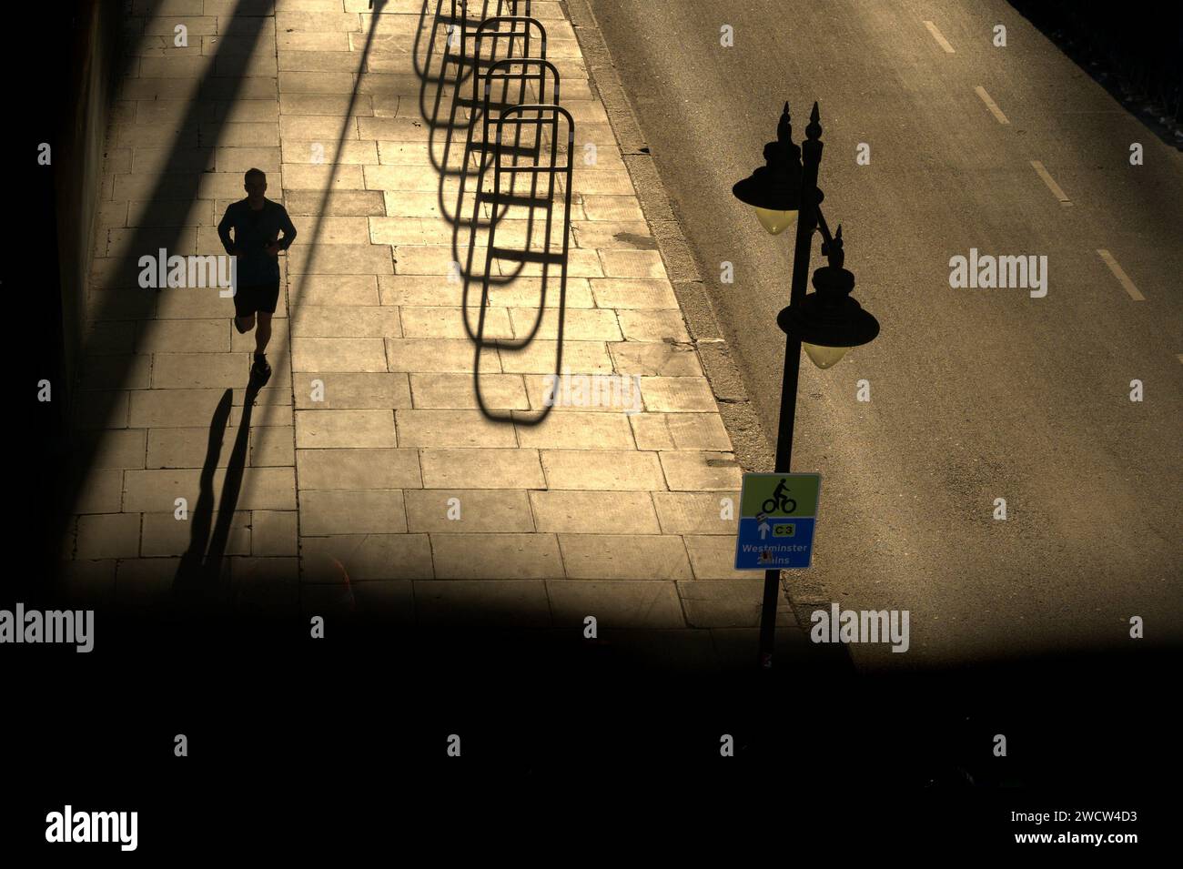 London, UK. Shadows under Waterloo Bridge in the evening - people and cycle racks Stock Photo