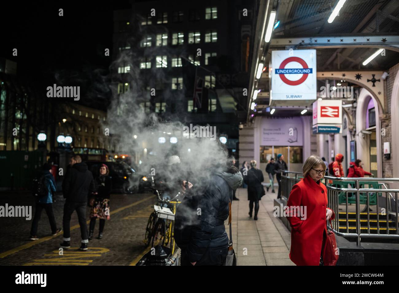 A puff of vape smoke floats in the winter night air outside Charing Cross Station, in London's West End, England, United Kingdom Stock Photo