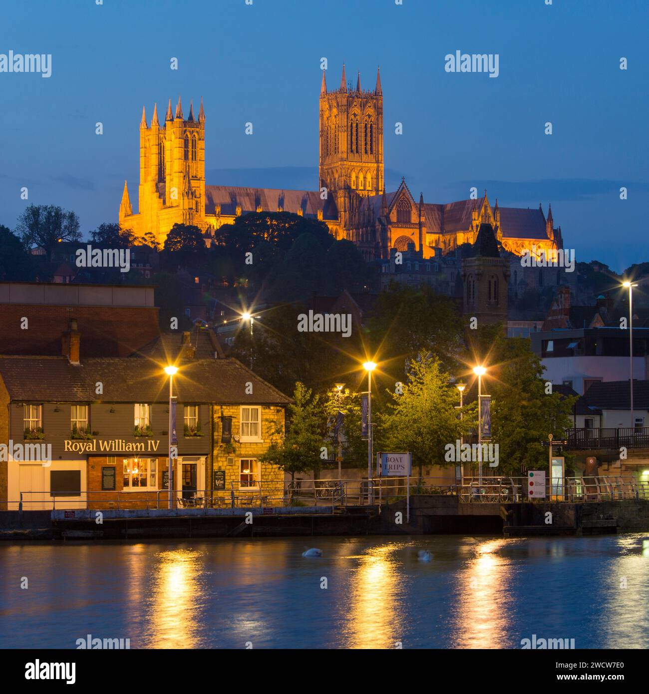 Lincoln, Lincolnshire, England. View across the quiet waters of the River Witham at Brayford Pool to illuminated Lincoln Cathedral, dusk. Stock Photo